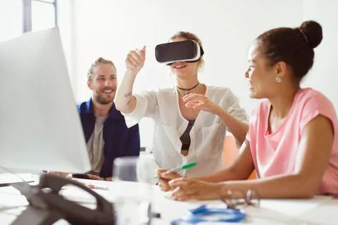Computer programmers testing virtual reality simulator glasses at computer in Foto stock