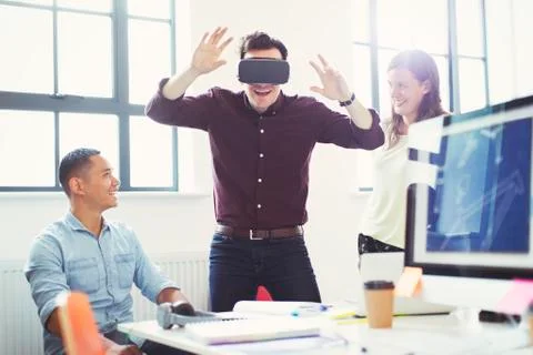 Computer programmers testing virtual reality simulator glasses in office Foto stock