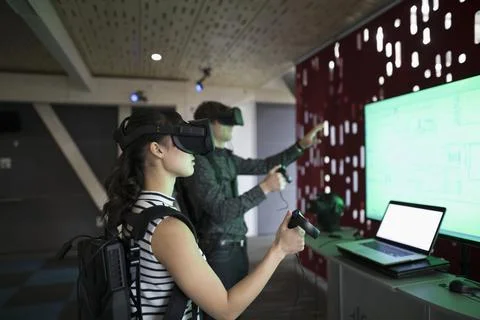Computer programmers testing virtual reality simulator glasses and joysticks in Stock-Fotos