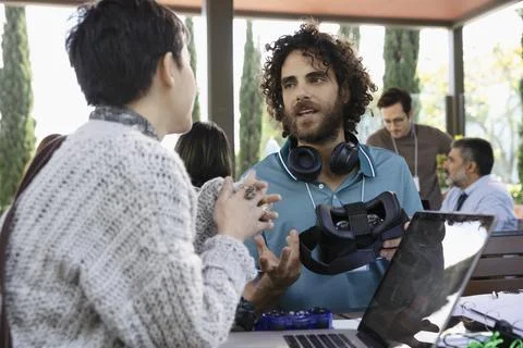 Computer programmers with virtual reality simulator talking in office Stock-Fotos