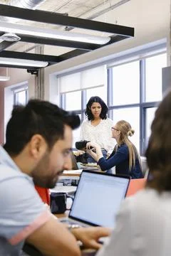 Computer programmers with virtual reality simulator glasses talking in office Stock-Fotos