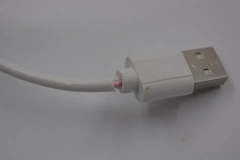 Computer quipment long, white micro USB cable for phone, computer located. Stock Photos
