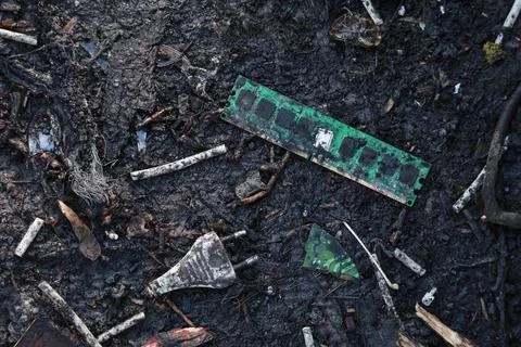 Computer RAM memory module lying in the mud as e-waste Stock Photos