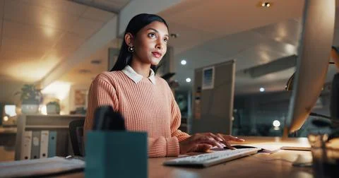 Computer, reading and typing with business woman in office for night, revenue Stock Photos