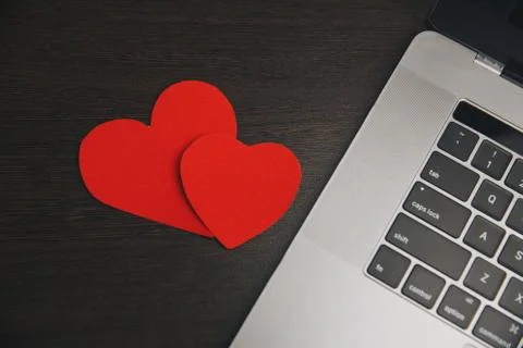 Computer with red hearts on table close up Stock Photos