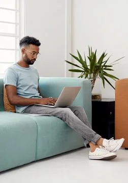 Computer, remote work and black man typing on sofa for research, project or 스톡 사진
