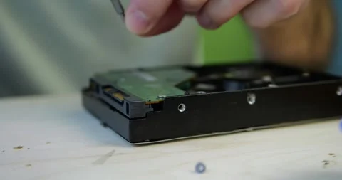 Computer repair. Close-up of hands unscrewing circuit board from computer hard Stock Footage 348486908