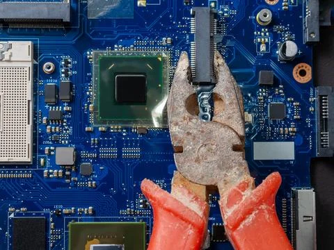 Computer repair concept. Old rusty passages on a blue laptop motherboard. The Stock Photos