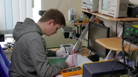 Computer repair service, man tech testing motherboard with tools Stock Footage 76625251