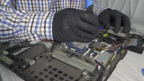 A computer repair technician disassembles a laptop Stock Footage 157783364