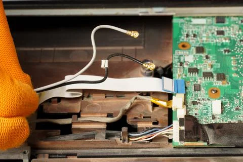 A computer repair technician disassembles a laptop for further cleaning or re 스톡 사진