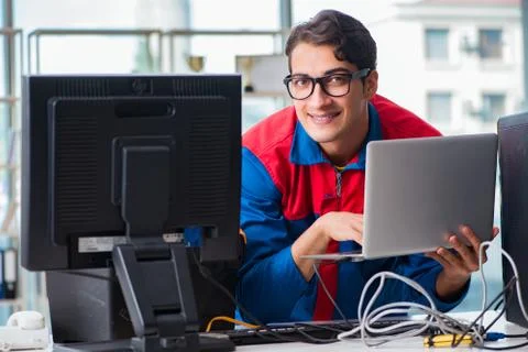 Computer repairman working on repairing computer in IT workshop 库存照片