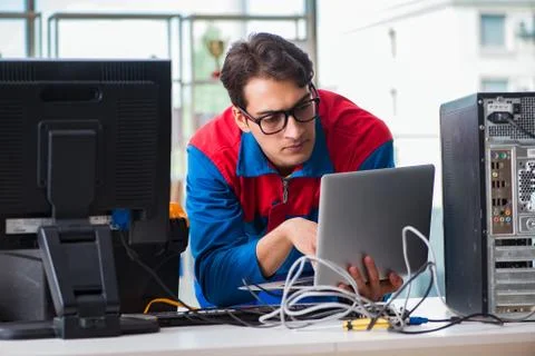 Computer repairman working on repairing computer in IT workshop 스톡 사진