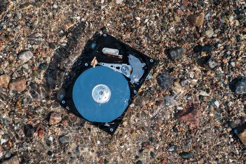 Computer rest disk lies in the shallow clear water of the sea Stock Photos