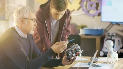 In Computer Science Class Teacher Examines programed Robot Engineered by His  스톡 사진