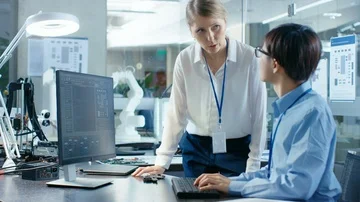 Computer Science Engineer Sitting at His Desk Consults Senior Engineer Stock Footage 85770417