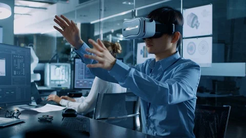 Computer Science Engineer wearing Virtual Reality Headset Works with 3D Modeling Stock Footage 104049367