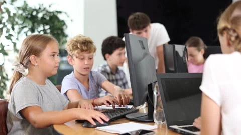 Computer science lesson in a school computer class - a girl and a boy solve Stock Footage 318435110