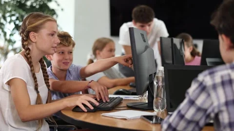 Computer science lesson in a school computer class - a girl and a boy solve Stock Footage 341380954