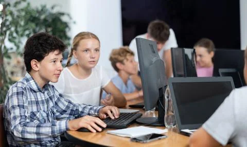 Computer science lesson in a school computer class - a girl and a boy solve Stock Photos