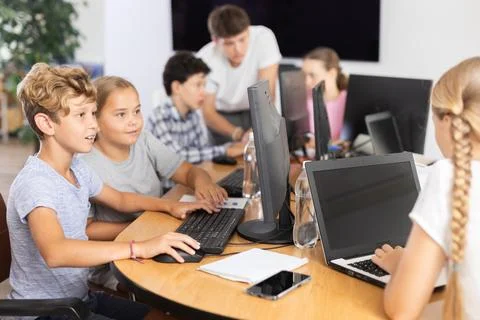Computer science lesson in a school computer class - a girl and a boy solve Stock Photos