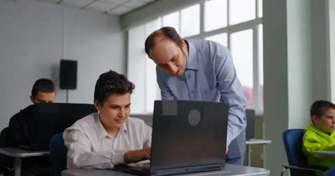 Computer Science Lessons In Middle School, Teacher Helping To Teen Boy Student Stock Footage 280172904
