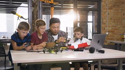 Computer science research class with Asian specialist and three pupils at Stock Footage 115507732