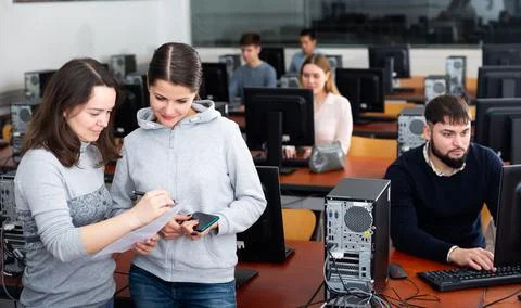 Computer science teacher checks student results Stock Photos