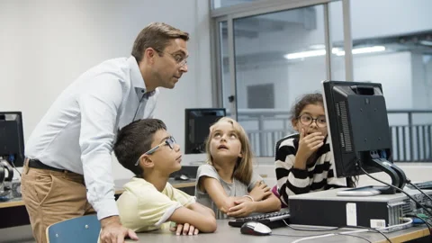 Computer science teacher discussing task with schoolchildren. Stock Footage 153830741