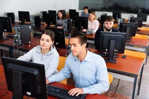 Computer science teacher supervises the execution of a programming task in a 库存照片