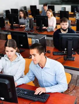 Computer science teacher supervises the execution of a programming task in a Stock Photos