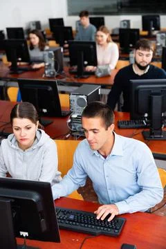 Computer science teacher supervises the execution of a programming task in a 库存照片