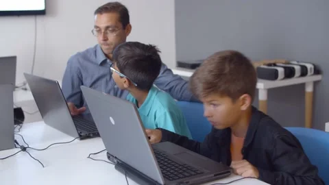 Computer science teacher teaching schoolboys to write codes Stock Footage 143282249