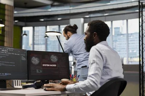 Computer scientist blocking network intrusion affecting office equipment Stock Photos