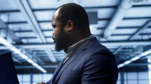 Computer scientist in data center facility using laptop to patch network issues Foto stock