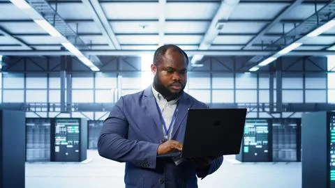 Computer scientist in data center using diagnostic tools on laptop Stock Photos