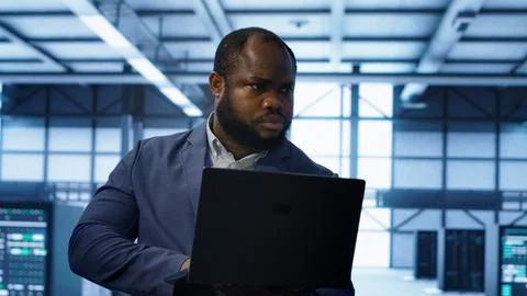 Computer scientist in data center using diagnostic tools on laptop Stock Photos