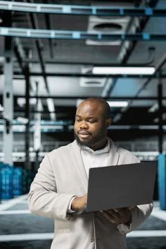 Computer scientist in data center using diagnostic tools on laptop Stock-Fotos