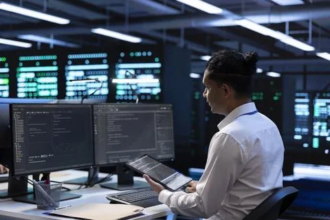 Computer scientist doing yearly checkup using tablet to safeguard data center Foto stock