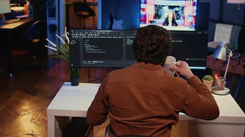 Computer scientist at home office desk writing binary code and drinking coffee Stock Footage 265507679
