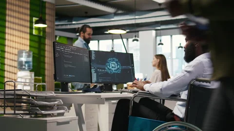 Computer scientist with paraplegia in office automating repetitive tasks with AI Stock Footage 313017400