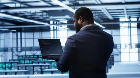 Computer scientist in server farm using laptop to patch network issues Foto stock