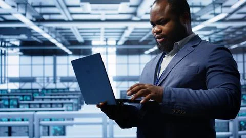 Computer scientist in server hub checking recovery plan on laptop 写真素材