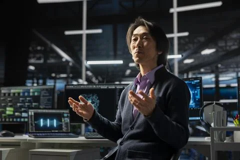 Computer scientist in server room using device to review diagnostics Stock Photos