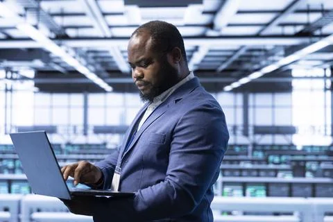 Computer scientist using laptop in data center with advanced tech Foto stock