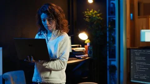 Computer scientist walking at home, developing software using laptop 스톡 사진