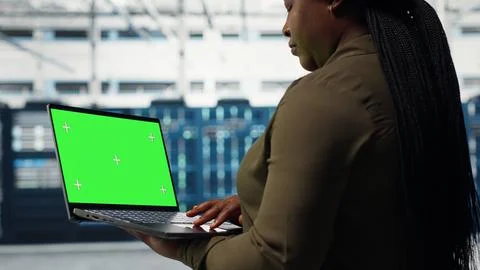 Computer scientist at work using green screen laptop in data center Stock Photos