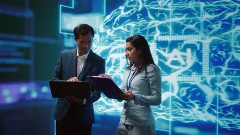 Computer scientists collaborating on developing AI system in high tech workspace Stockfoto's