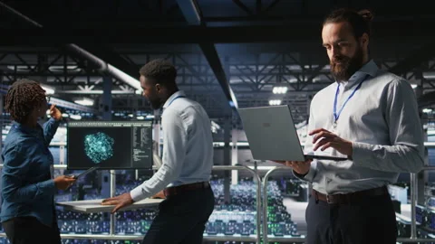 Computer scientists on data center platform analyzing performance outputs Stock Footage 310784007