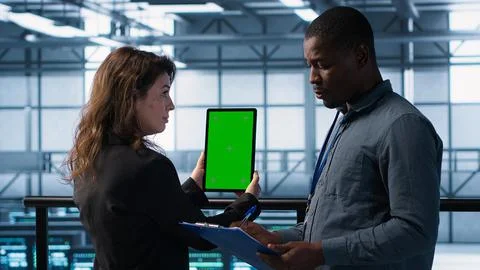 Computer scientists in data center use mockup tablet, inspecting server rigs Stock Photos